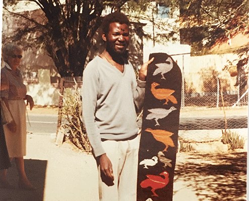 John Muafangejo holding a woven panel of birds, Windhoek